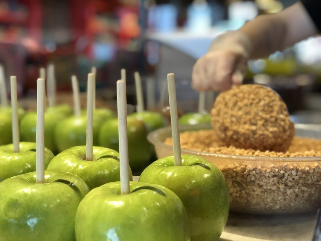 Making carmel apples covered with nuts